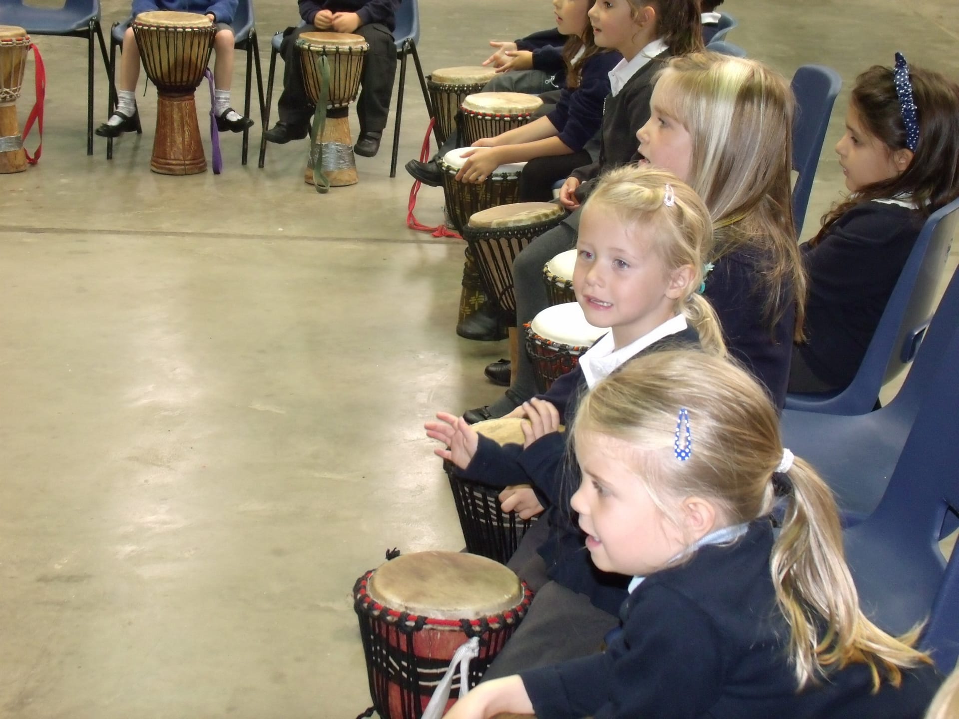 Children in school playing African Drums