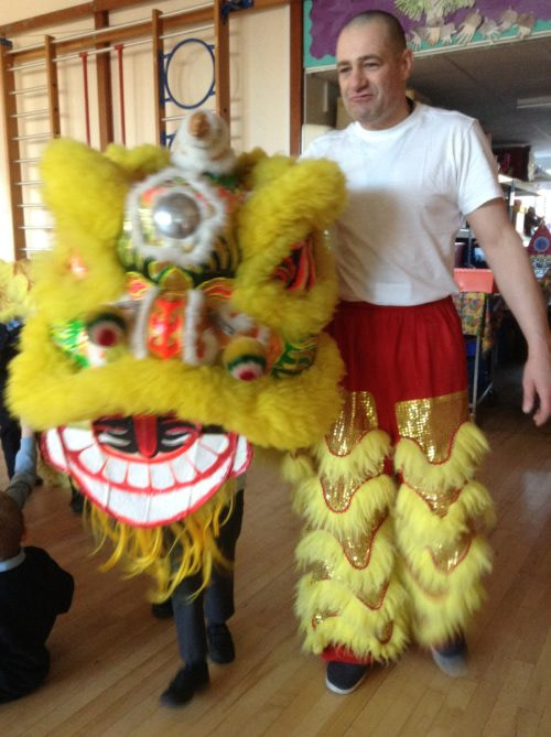 Teacher holding on yellow Chinese lion dance costume