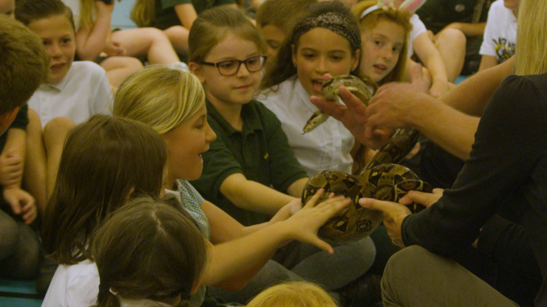 School children holding a snake