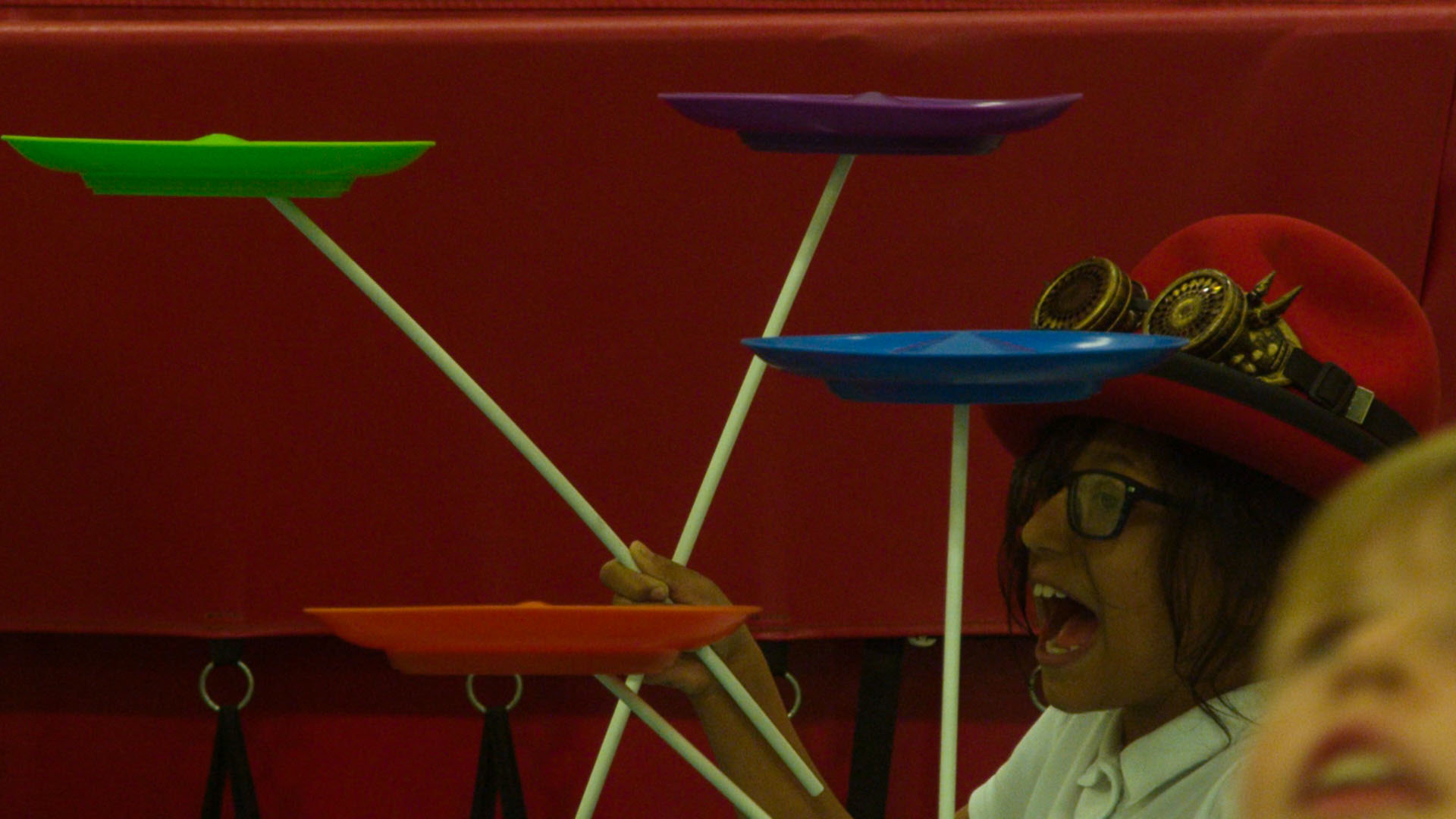 School children balancing different coloured plates in circus workshop
