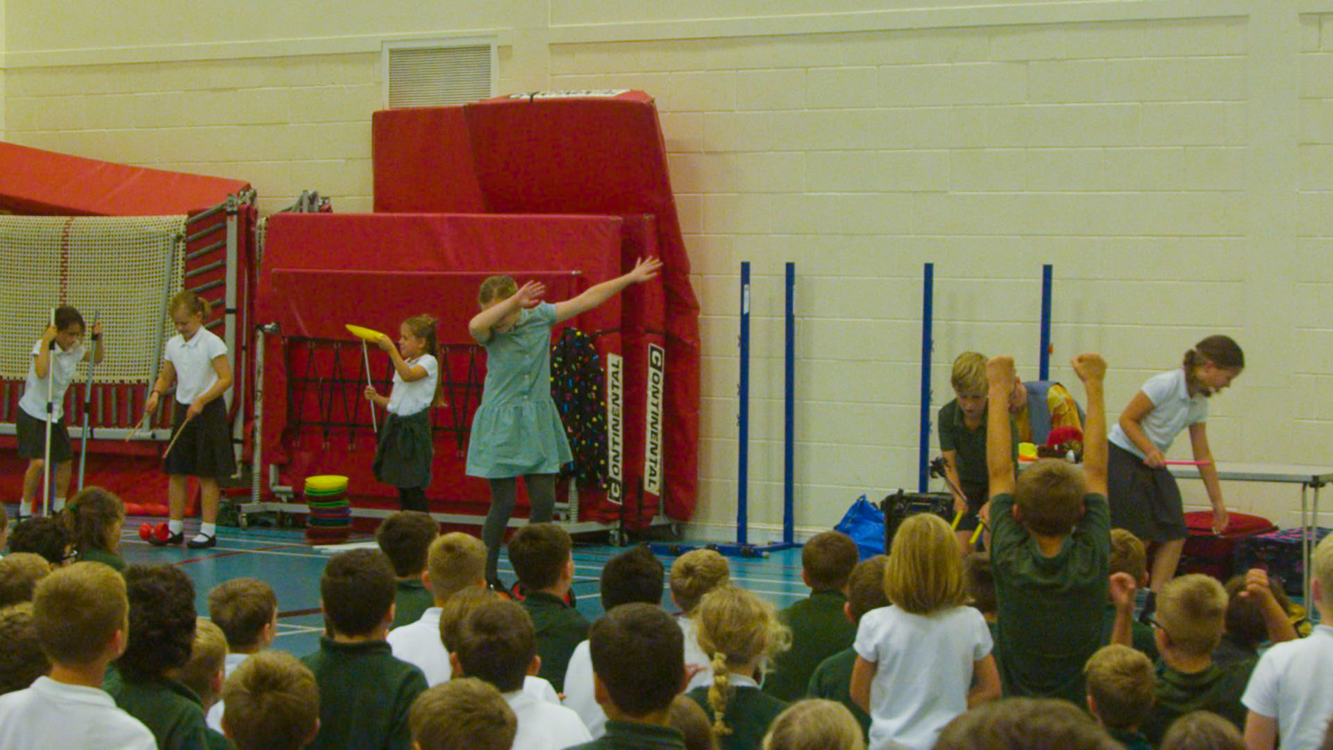 School children performing circus skills in school hall