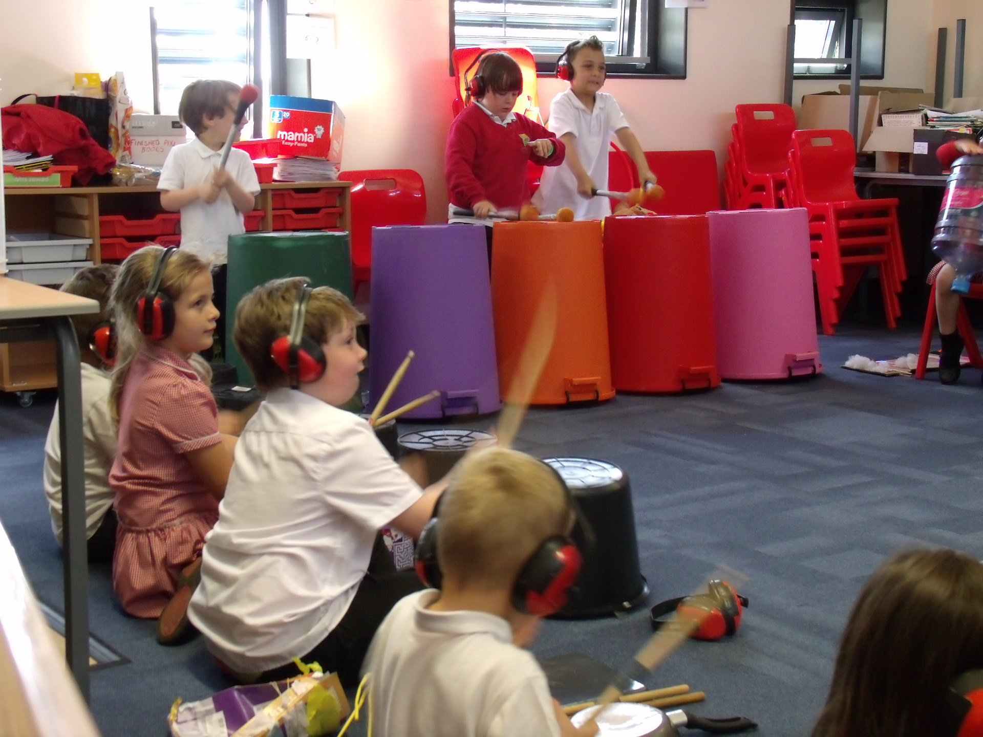 School children playing musical instruments made out of household objects