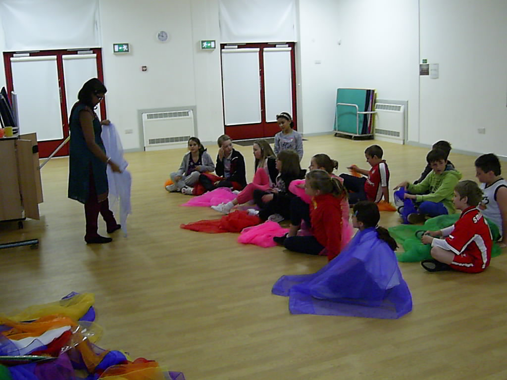 School children sitting in school hall learning about indian textiles