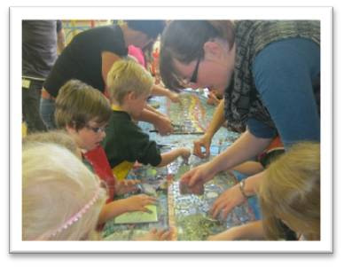 School children creating a mosaic with teacher