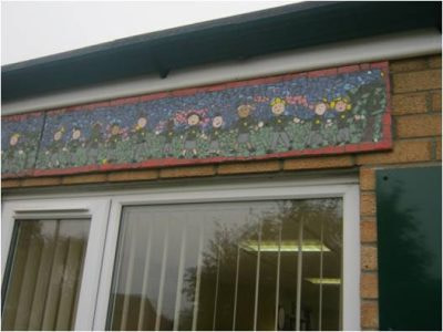Finished mosaic on wall featuring school children in a line