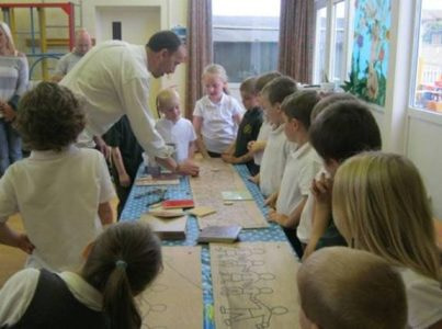 School children drawing out a design for a mosaic